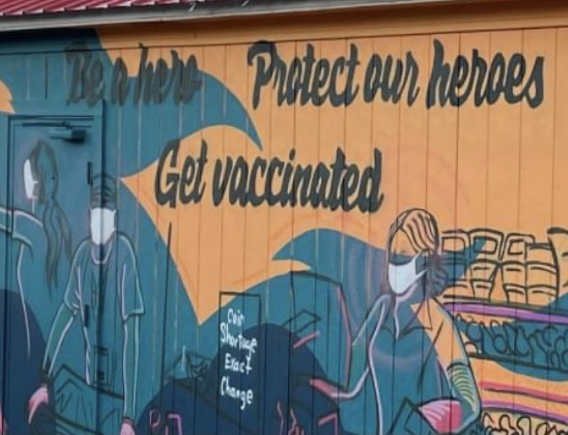 Zoomed in photo of mural that reads: "Be a hero. Protect our heroes. Get vaccinated."