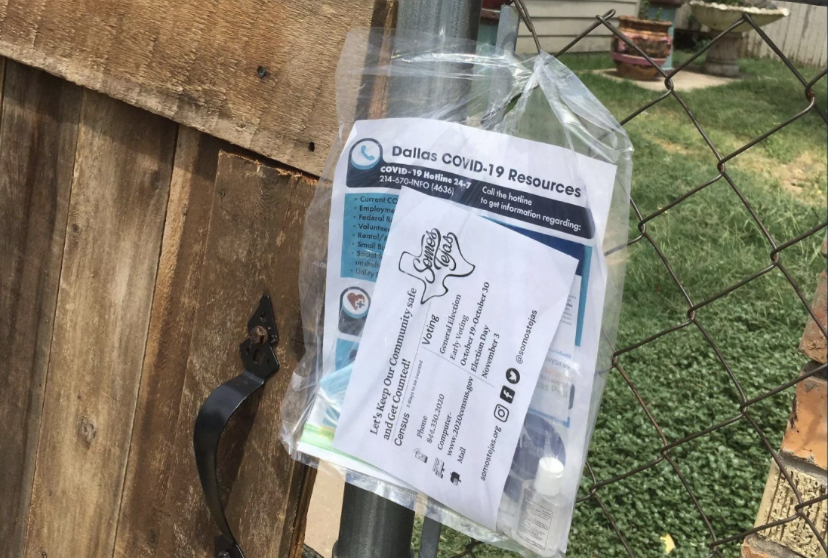 Plastic bag with face masks, hand sanitizer, and flyer attached to gte