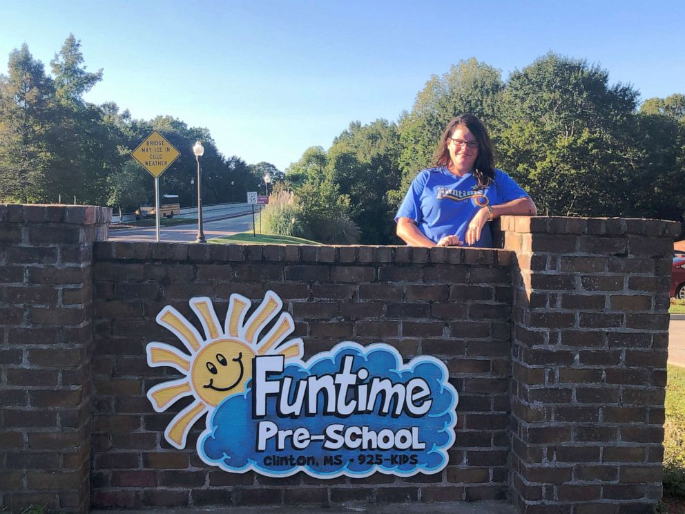 Image of woman posing with school sign